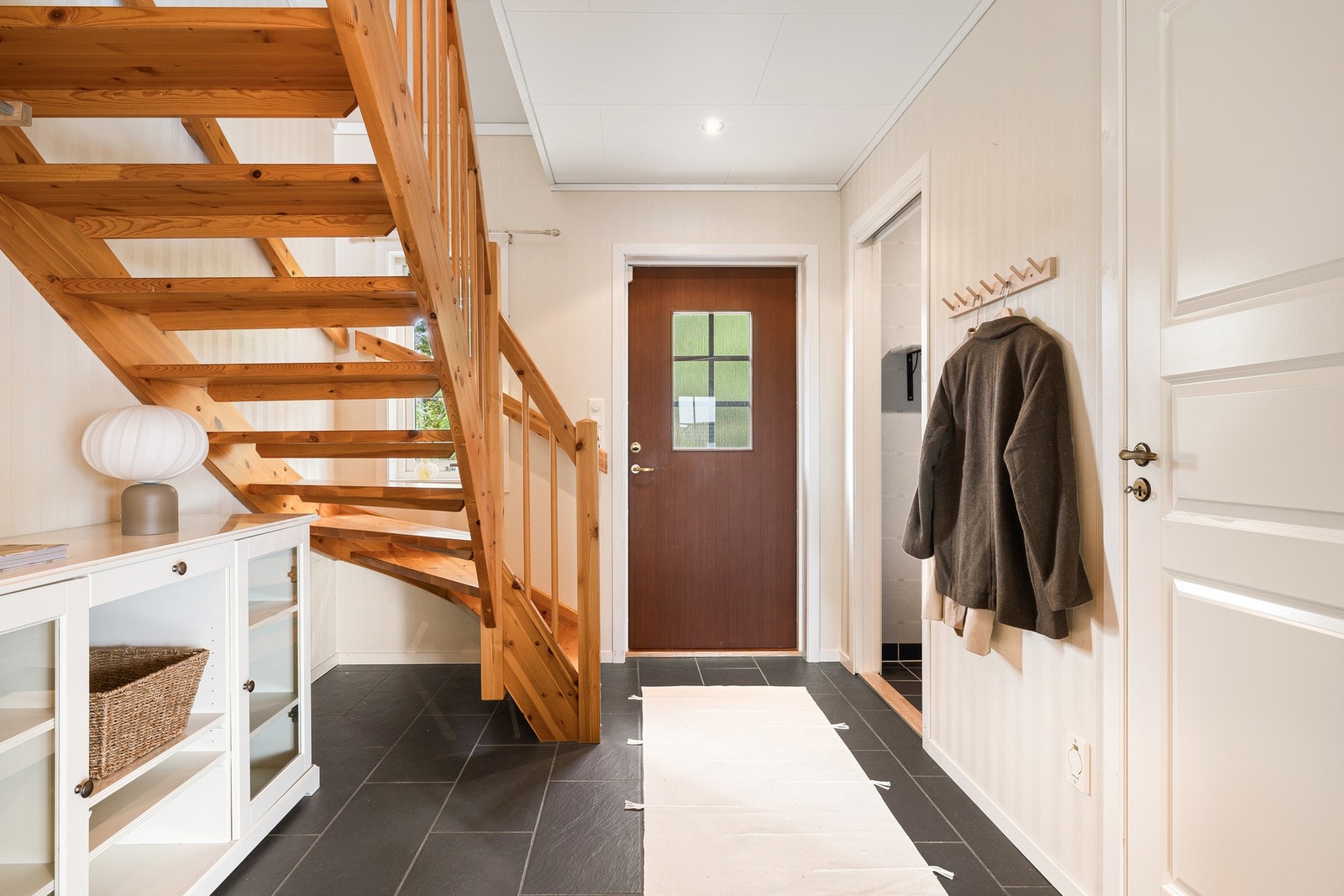 Velkommen inn! I første etasje blir du ønsket velkommen av en romslig hall med trapp på ca. 12,5 m². Her er det god plass til garderobe og oppbevaring, samtidig som hallen gir en naturlig forbindelse mellom boligens ulike rom. Galleribilde