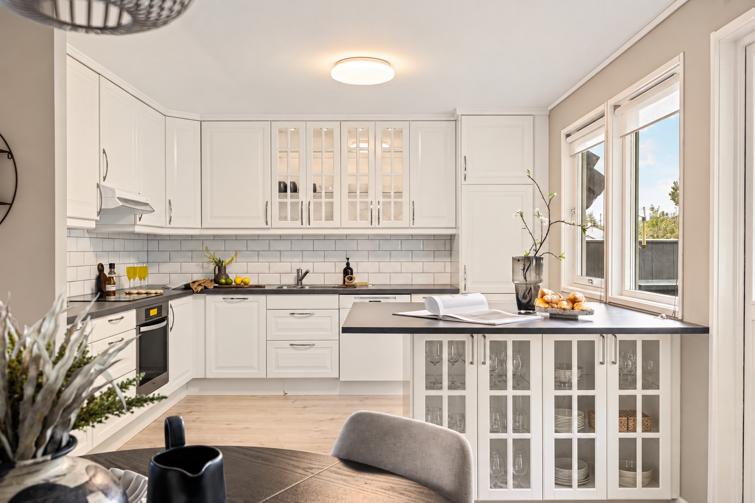 Kjøkkenet har IKEA-innredning fra 2013 med profilerte hvite fronter, takhøye skap og glassfronter. Galleribilde