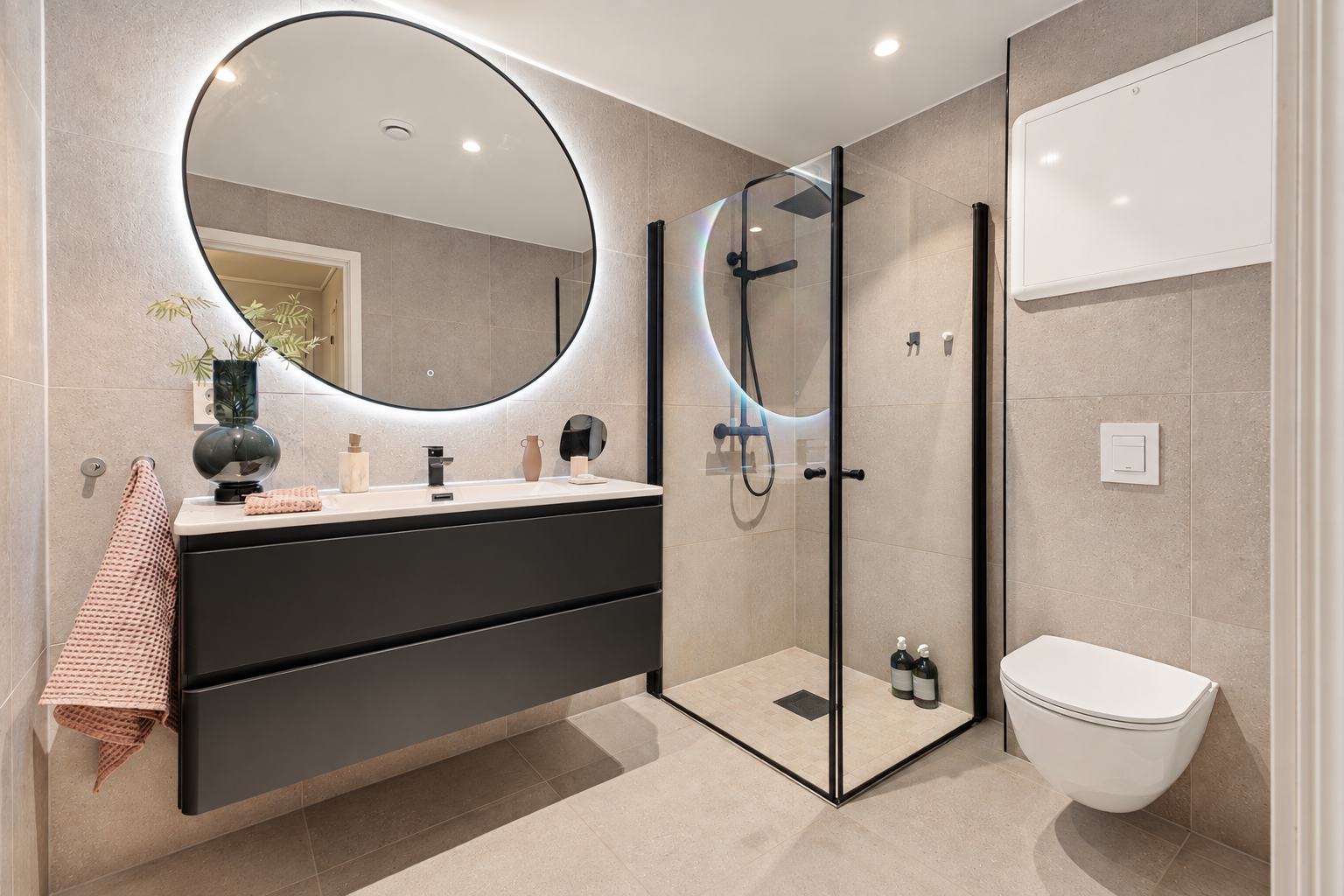 Badet er på ca. 4,6 m² og ble renovert i 2023. Rommet har keramiske fliser på gulv og vegger, varmekabler og malt himling med innfelte LED-spotlights. Galleribilde