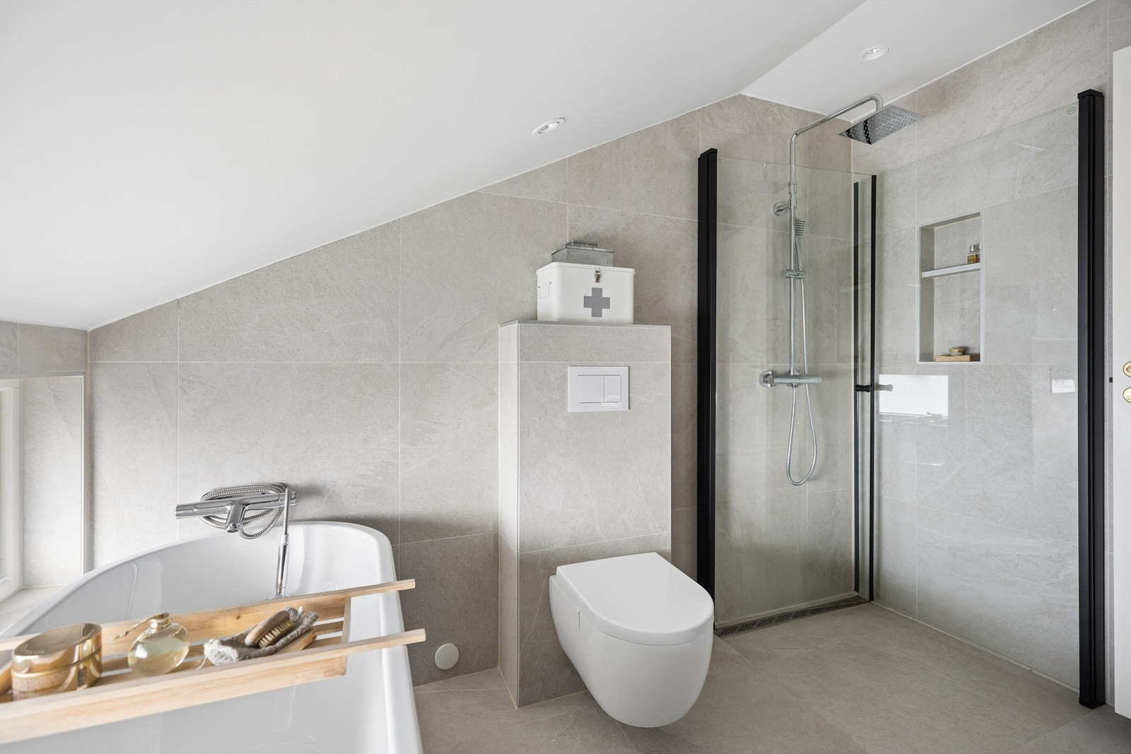 Lekkert, flislagt bad oppgradert i 2020. Badet fremstår som moderne og innbydende med badekar, dusjhjørne, servantinnredning og vegghengt toalett. Galleribilde