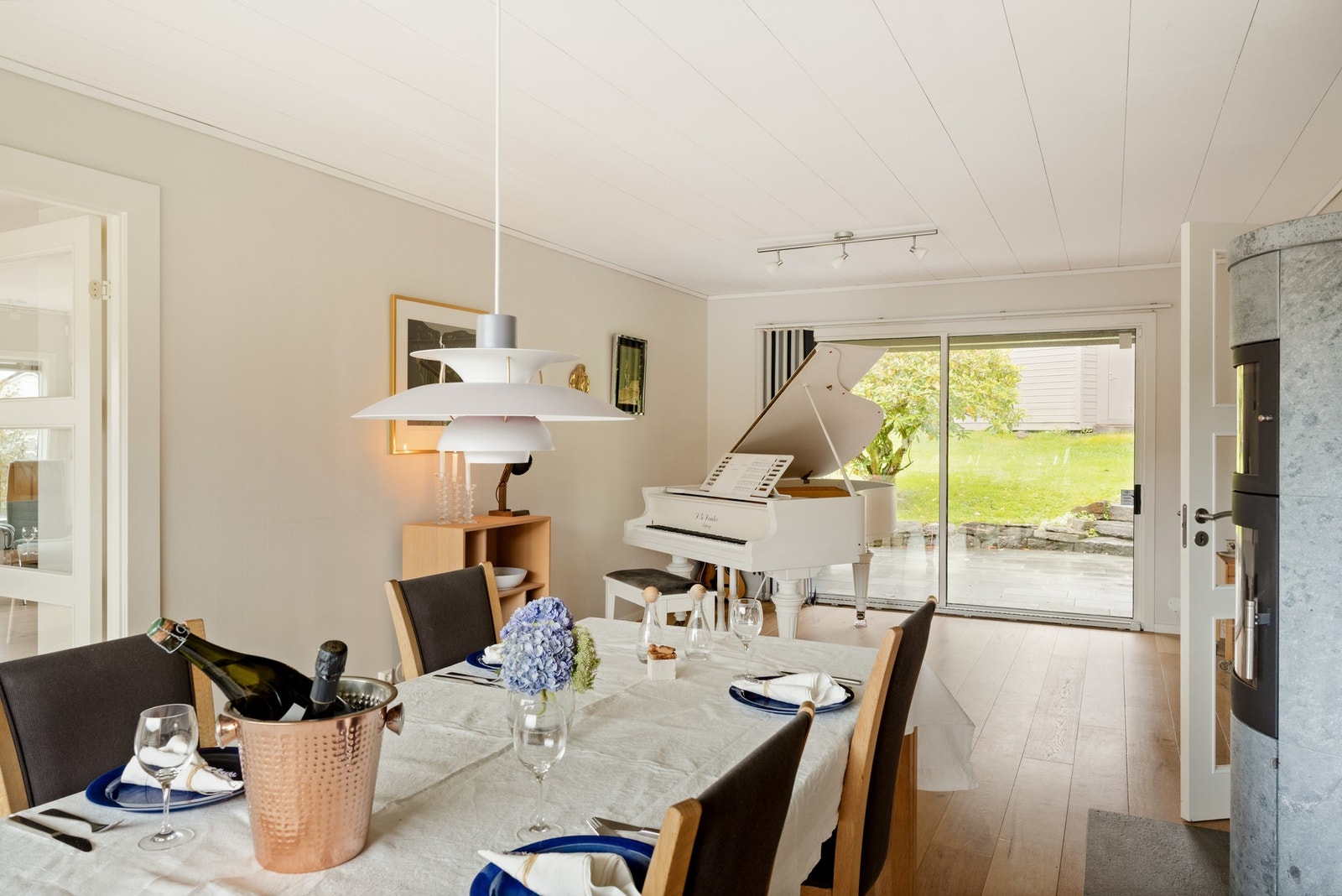 Tilbake i spisestuen trekkes blikket mot utsikten og Gullfjellet, mens glass fra gulv til tak på motsatt side vender mot det overbyggede inngangspartiet og den grønne baksiden av hagen. Galleribilde