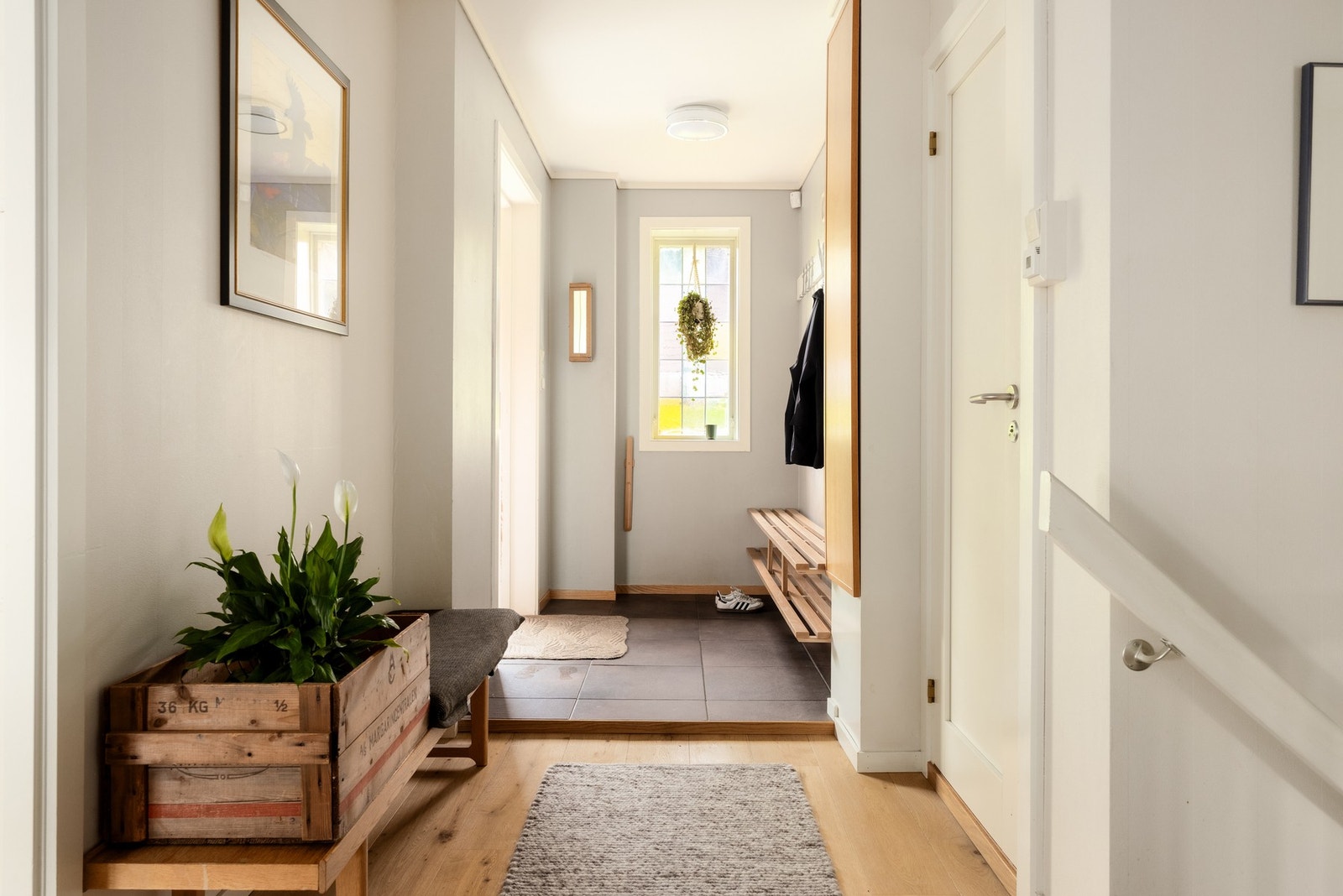 Hallen i hovedetasjen er på ca. 15 kvm og har fliser og parkett på gulvet. Herfra fordeles boligens øvrige rom, samtidig som trappen skaper forbindelse til den innholdsrike underetasjen. Det er også gode oppbevaringsmuligheter i skyvedørsgarderobe, lang k Galleribilde