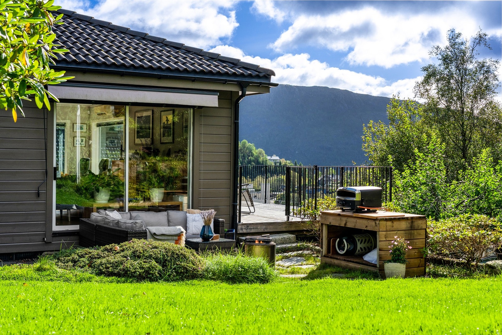 Ved huset ligger også en terrasse belagt med skiferheller. Her er det etablert en arbeidsbenk som fungerer fint som et enkelt utekjøkken. Galleribilde