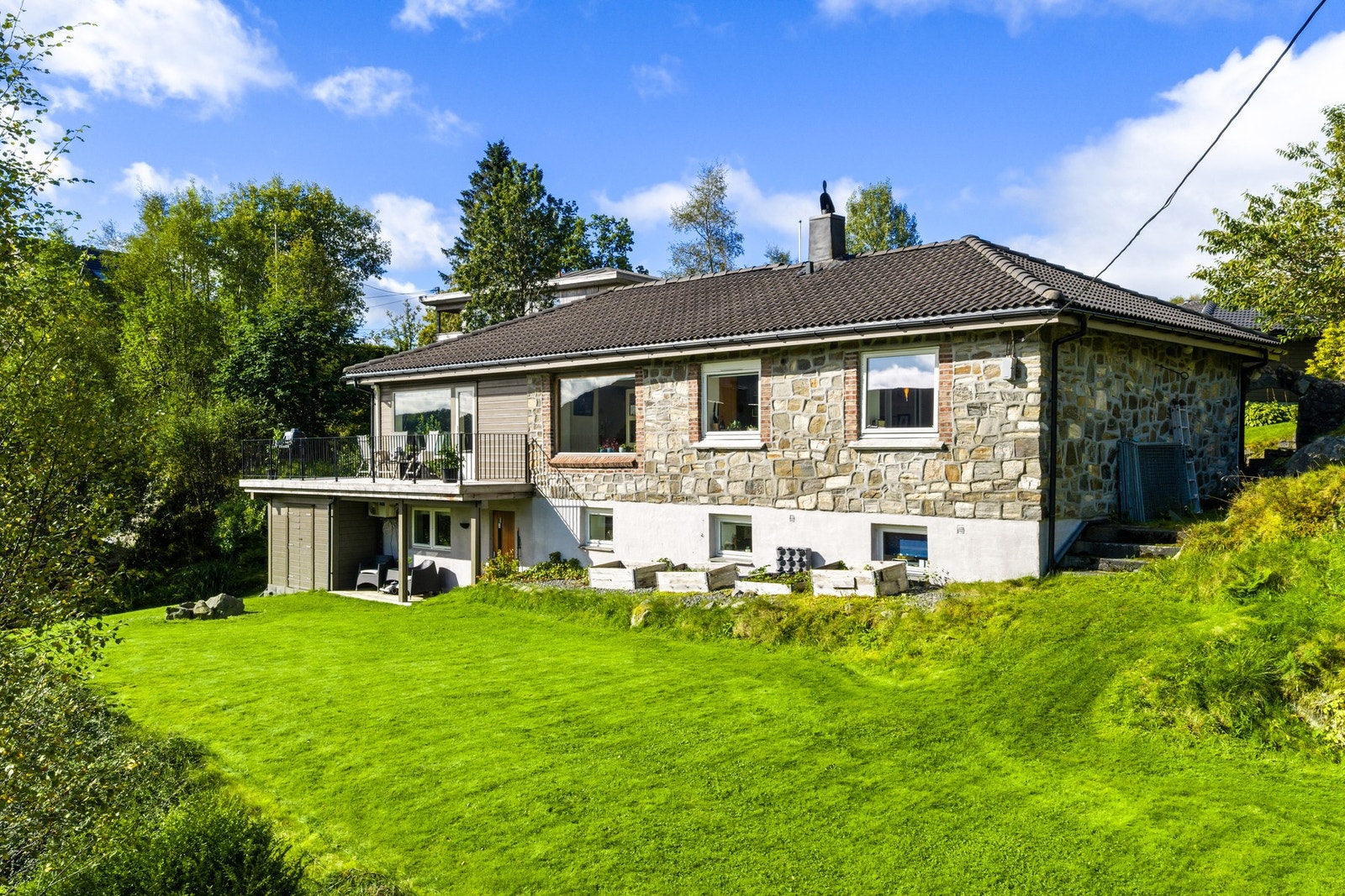 Dette er samtidig en hage som tåler å bli brukt. Den store gressplenen gir rom for fotball, badminton og kubb, og for den hageinteresserte finnes det gode muligheter for å dyrke egne bær, frukt og grønnsaker. Galleribilde