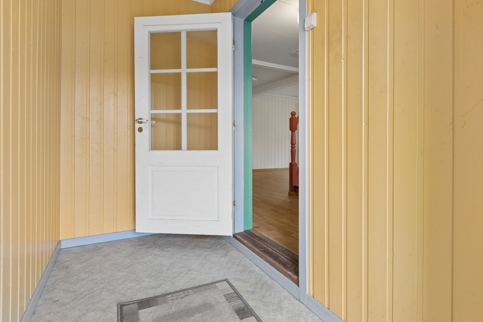 Vindfanget har panelkledde vegger og dør videre inn til hallen. Galleribilde