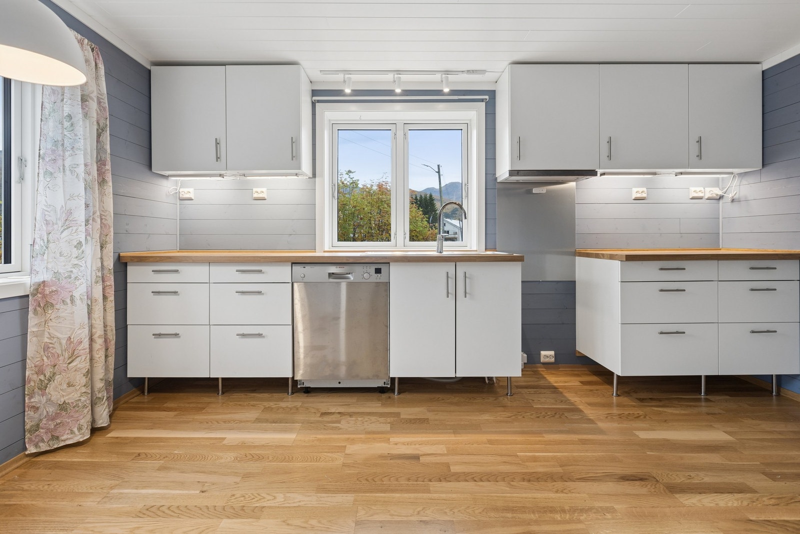 Kjøkkeninnredning med laminatbenkeplate, skuffeseksjoner og oppvaskmaskin. Galleribilde