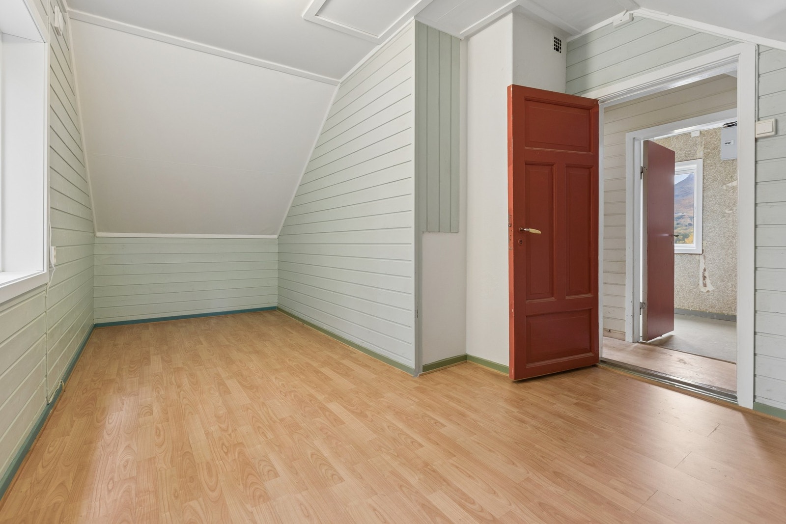 Soverom i loftsetasjen med skråtak, malt panel og laminatgulv. Galleribilde