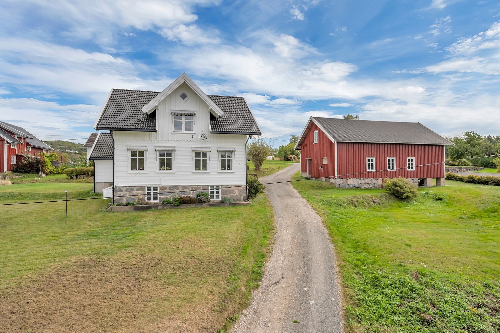 Gruslagt innkjørsel fører opp til tunet mellom boligen og låven. Galleribilde