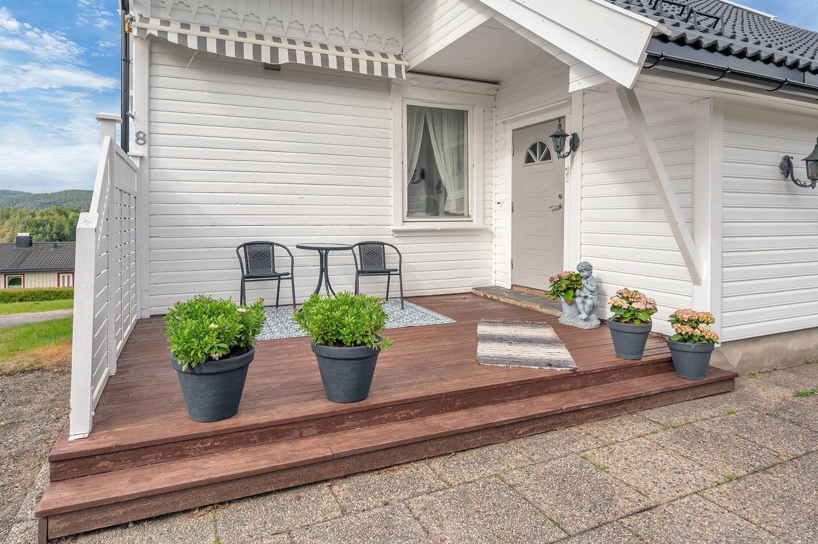 Markterrasse i trekonstruksjon med plass til sittegruppe ved inngangspartiet. Galleribilde