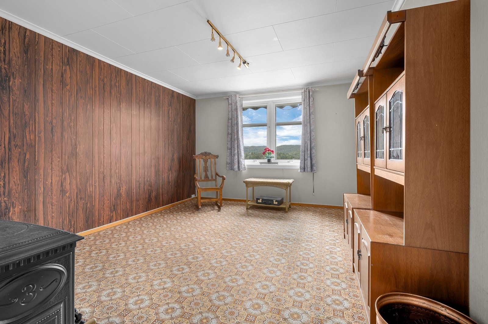 Loftstuen har panelkledd fondvegg og utsyn mot landskapet. Galleribilde