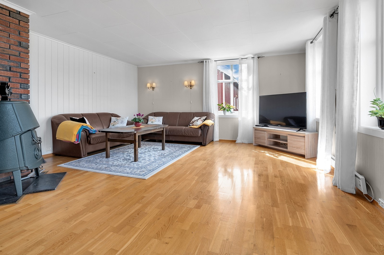 Stuen har montert vedovn og god plass til sittegruppe. Galleribilde