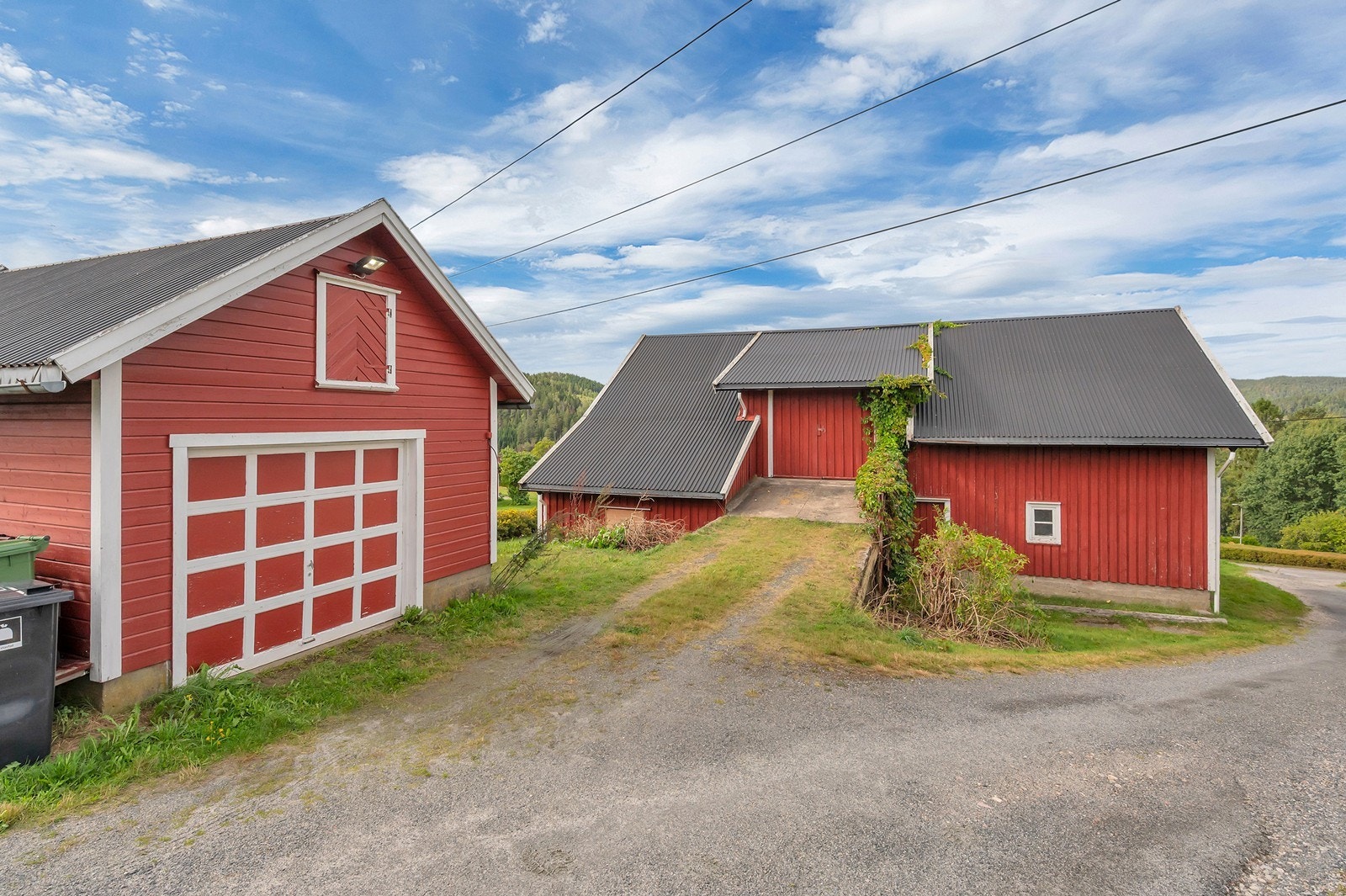 Garasje med leddport og innkjøring like ved låvebroen. Galleribilde