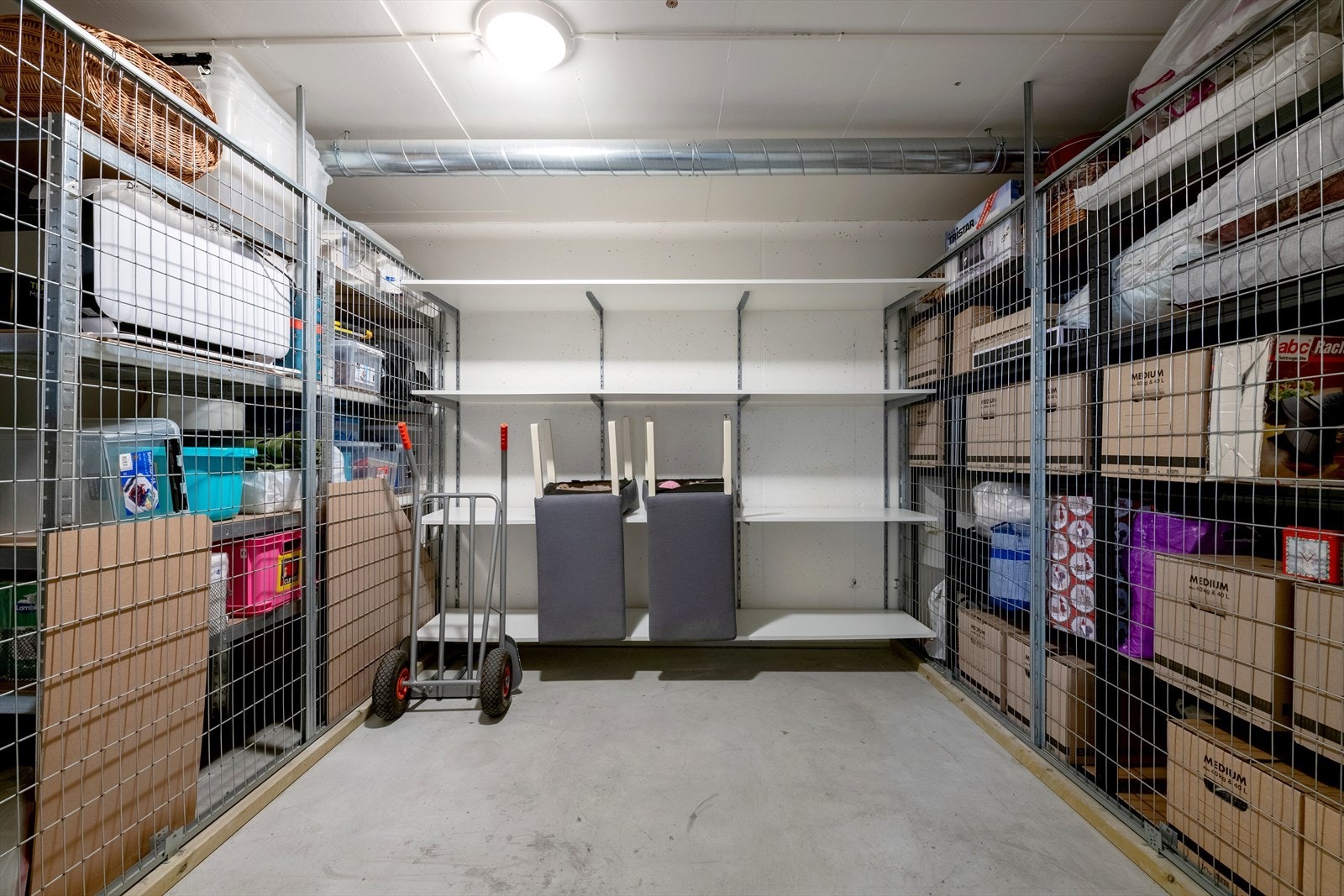 Kjellerboden har betonggulv, betong-/flettverksvegger, innlagt lys og enkel ståldør. Galleribilde