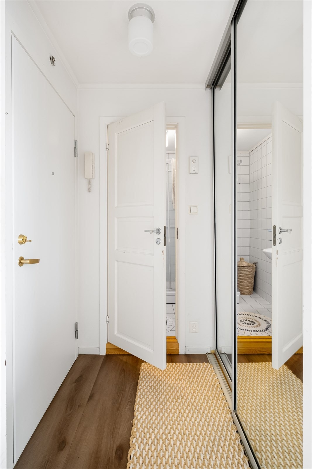 Romslig entrè utstyrt med porttelefon og skyvedørsgarderobe for optimal oppbevaring. Galleribilde