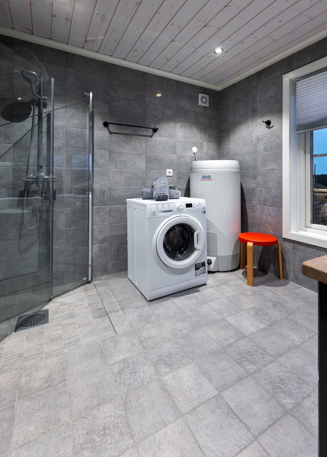 Badet er innredet med dusjhjørne/dusjvegger, toalett, servant, varmtvannsbereder, rør i rør skap og opplegg for vaskemaskin. Det er montert el vifte i vegg. Galleribilde