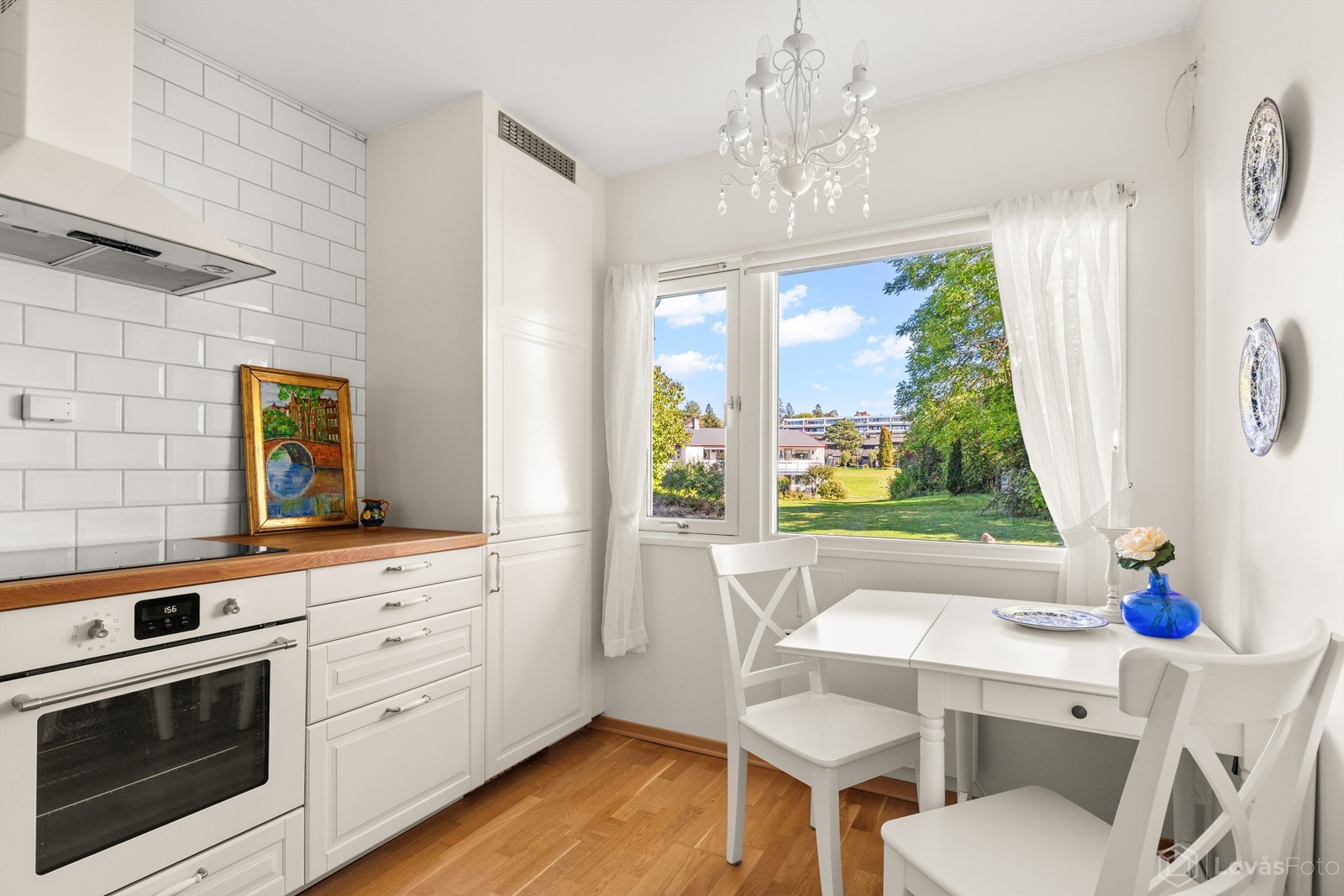 Kjøkken med profilerte fronter, benkeplate i heltre og spiseplass ved vinduet.
Foto: Løvås Foto Galleribilde