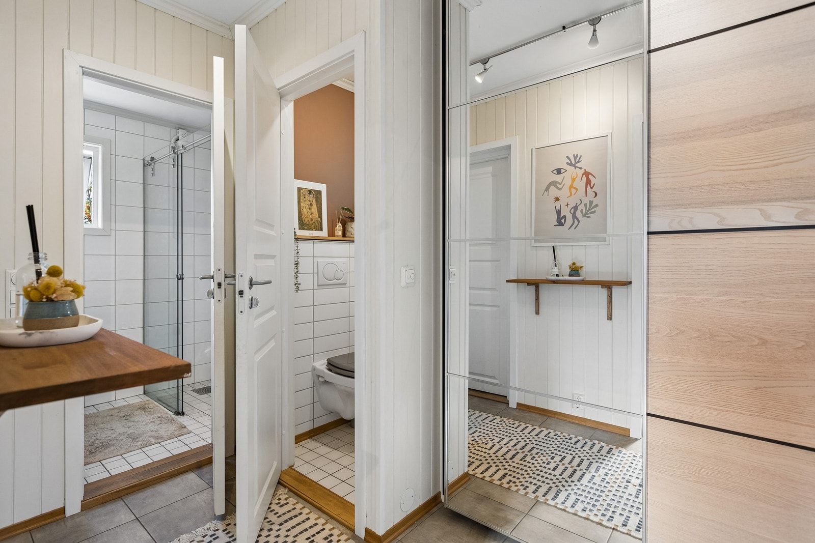 Gangen er romslig med god plass til skyvedørsgarderobe som sørger for praktiske oppbevaringsmuligheter. Herfra er det videre adkomst til et separat toalettrom og et flislagt bad. Galleribilde