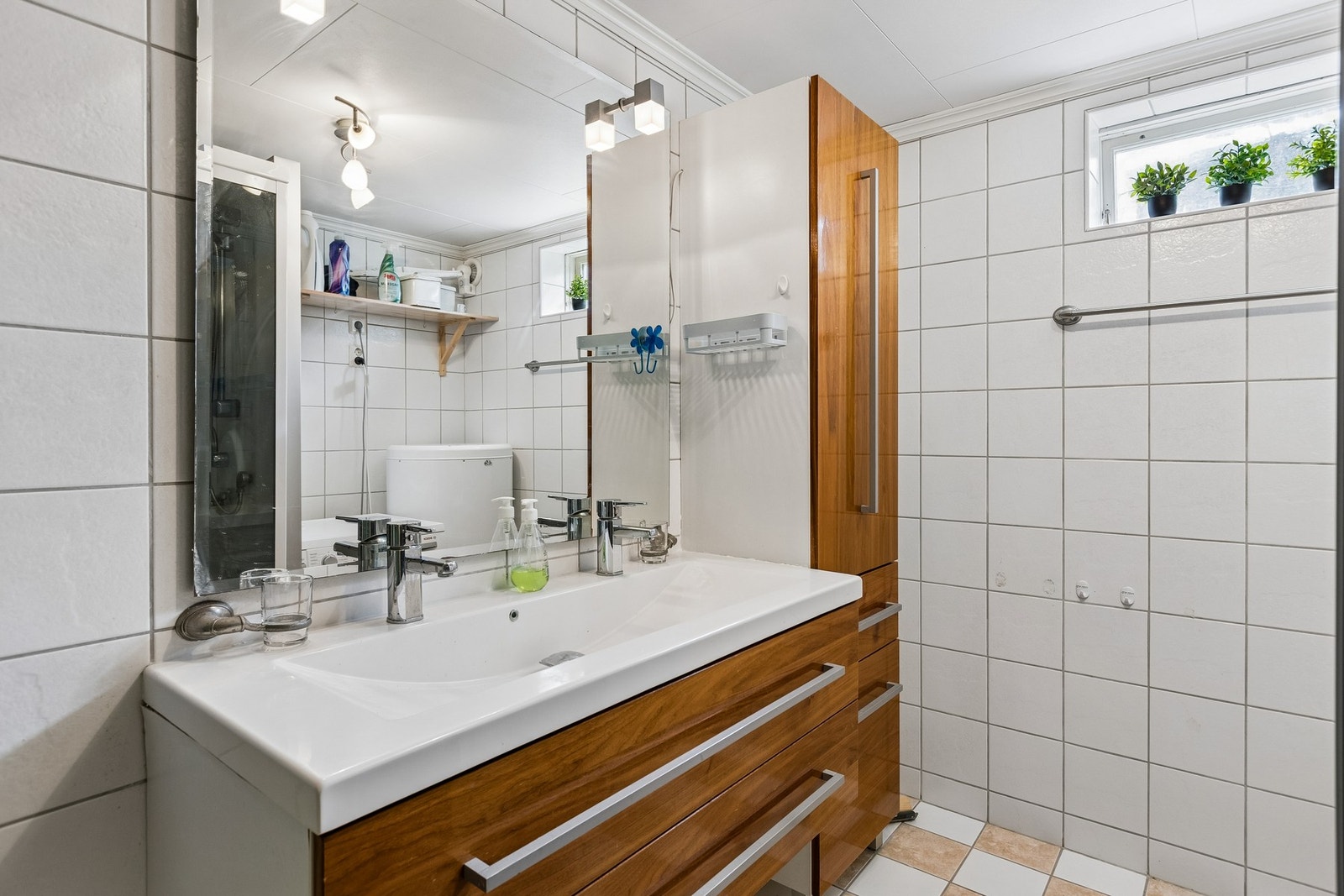 Bad i kjeller med servantinnredning og opplegg for vaskemaskin Galleribilde