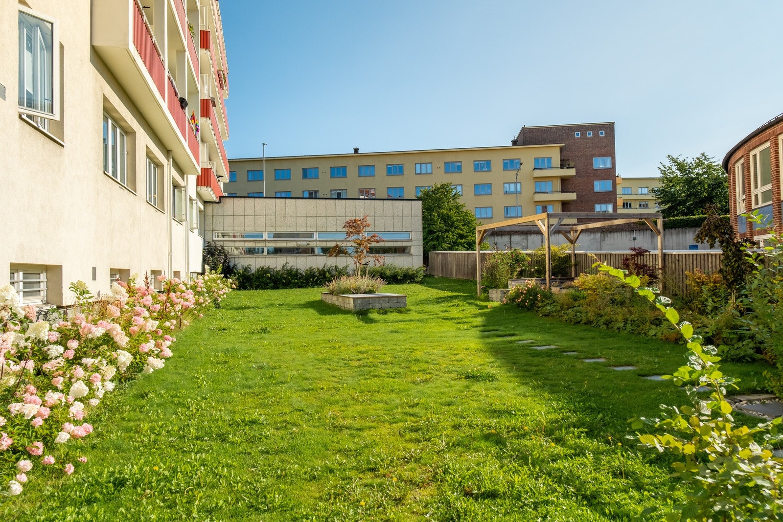Bakhagen er velstelt og pen, med vakre blomster og enda fler sittegrupper. Galleribilde