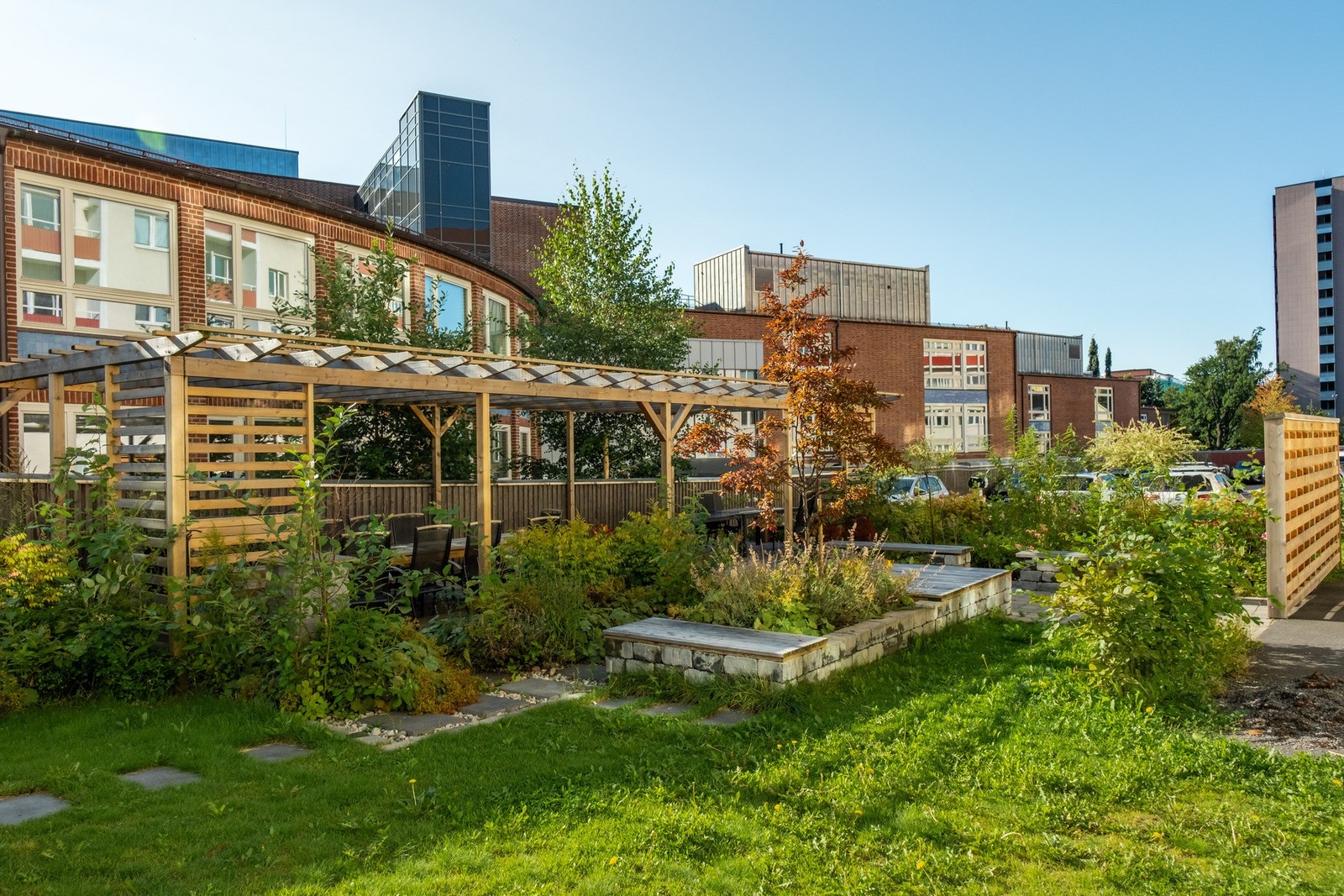 Aksjelaget har flotte grøntområder utenfor, med blant annet sittegrupper og pergola. Galleribilde