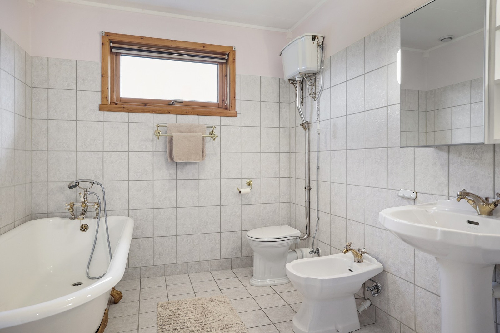 Bad i 2. etasje med fliser på gulv og vegger, utstyrt med badekar. Galleribilde