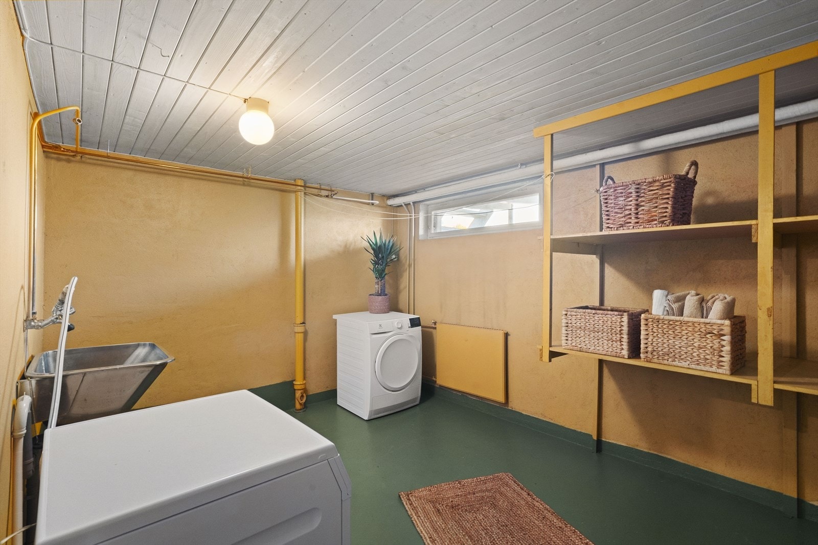Underetasjen har et romslig og praktisk vaskerom utstyrt med stor utslagsvask samt opplegg for vaskemaskin og tørketrommel. Galleribilde