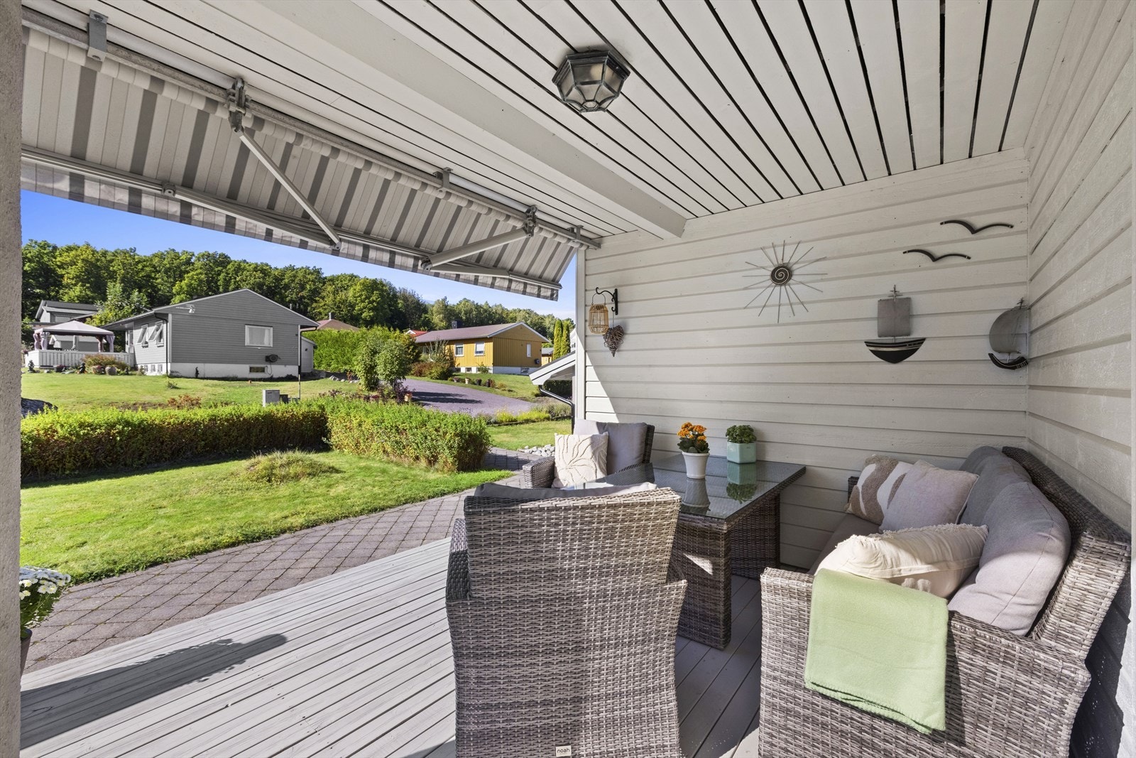 På fremsiden ligger en romslig, vestvendt terrasse med overbygg og markise, en perfekt plass for lune ettermiddager og kvelder. Galleribilde