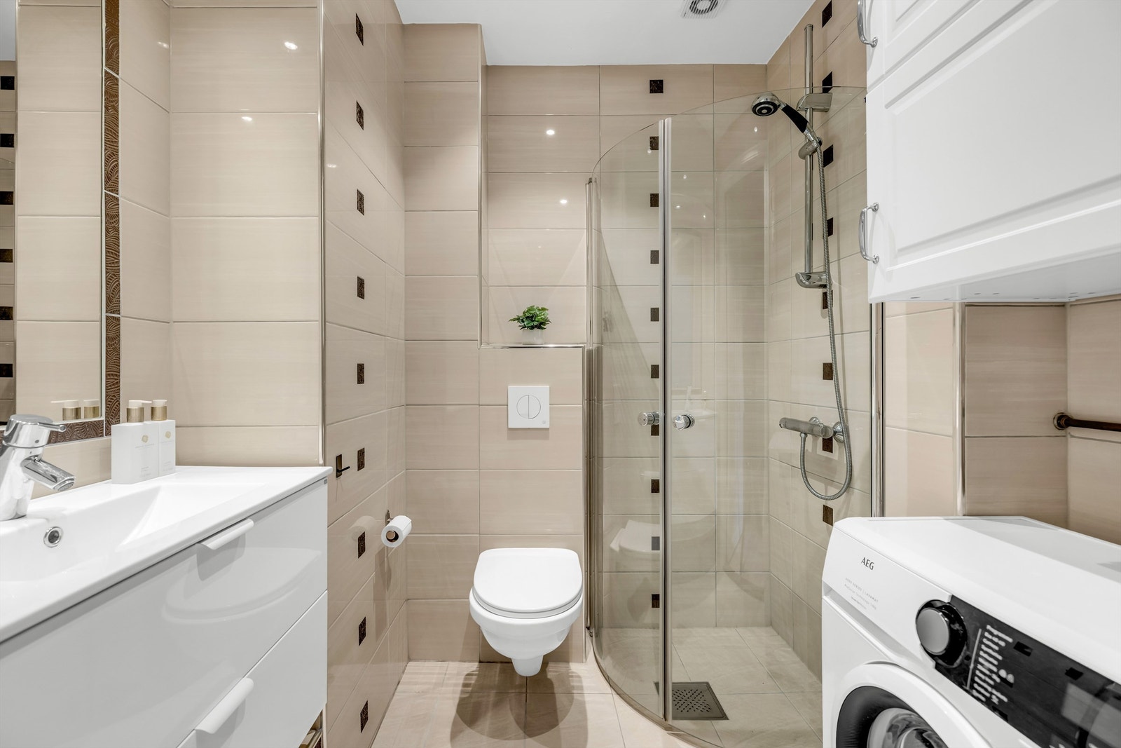 Pent flislagt baderom med gulvvarme og downlights. Galleribilde