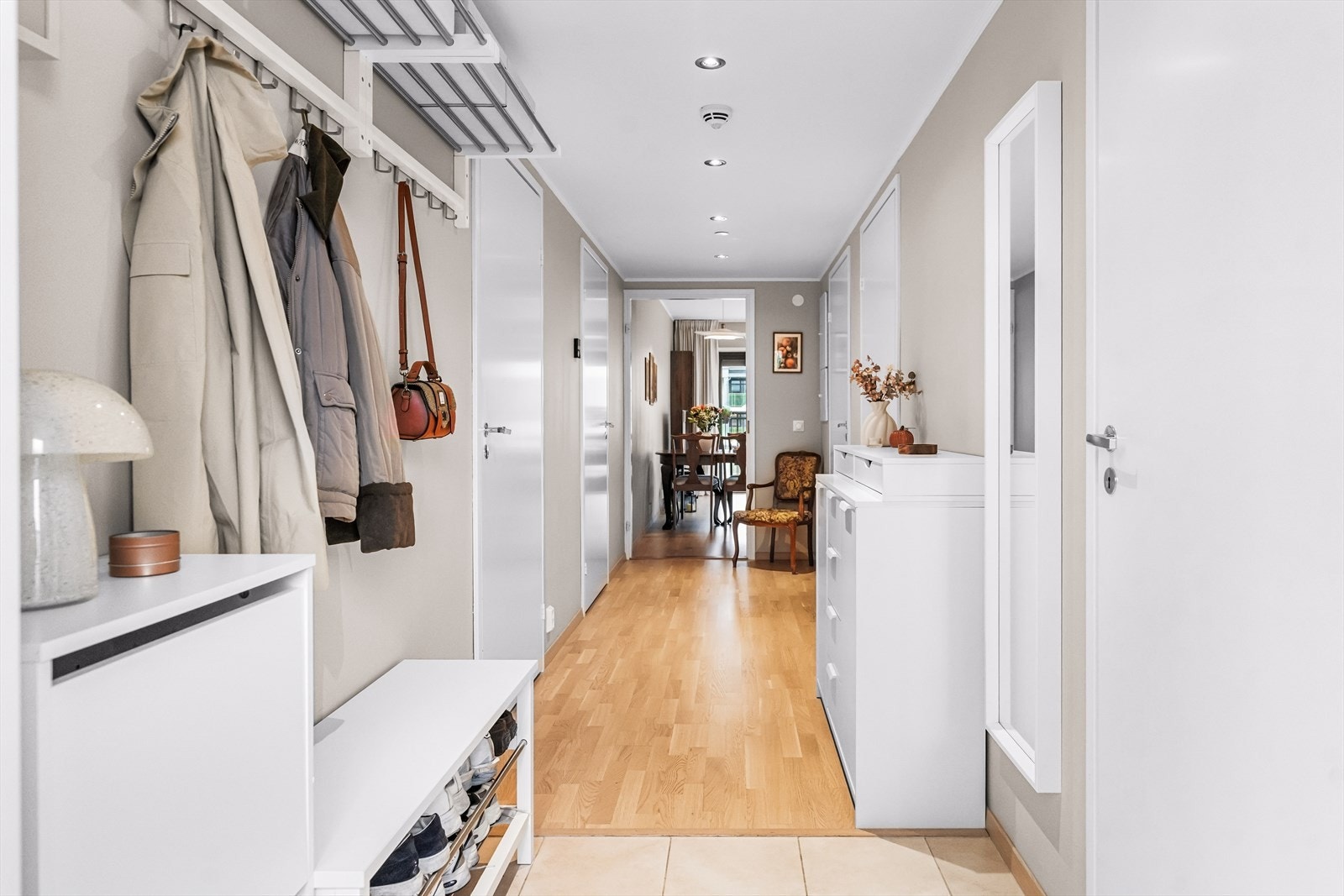 Velkommen inn i en praktisk entré med adkomst videre til boligens øvrige rom. Praktiske hyller med knagger til å henge fra seg yttertøy og øvrig møblement som matcher førsteinntrykket av boligen. Galleribilde