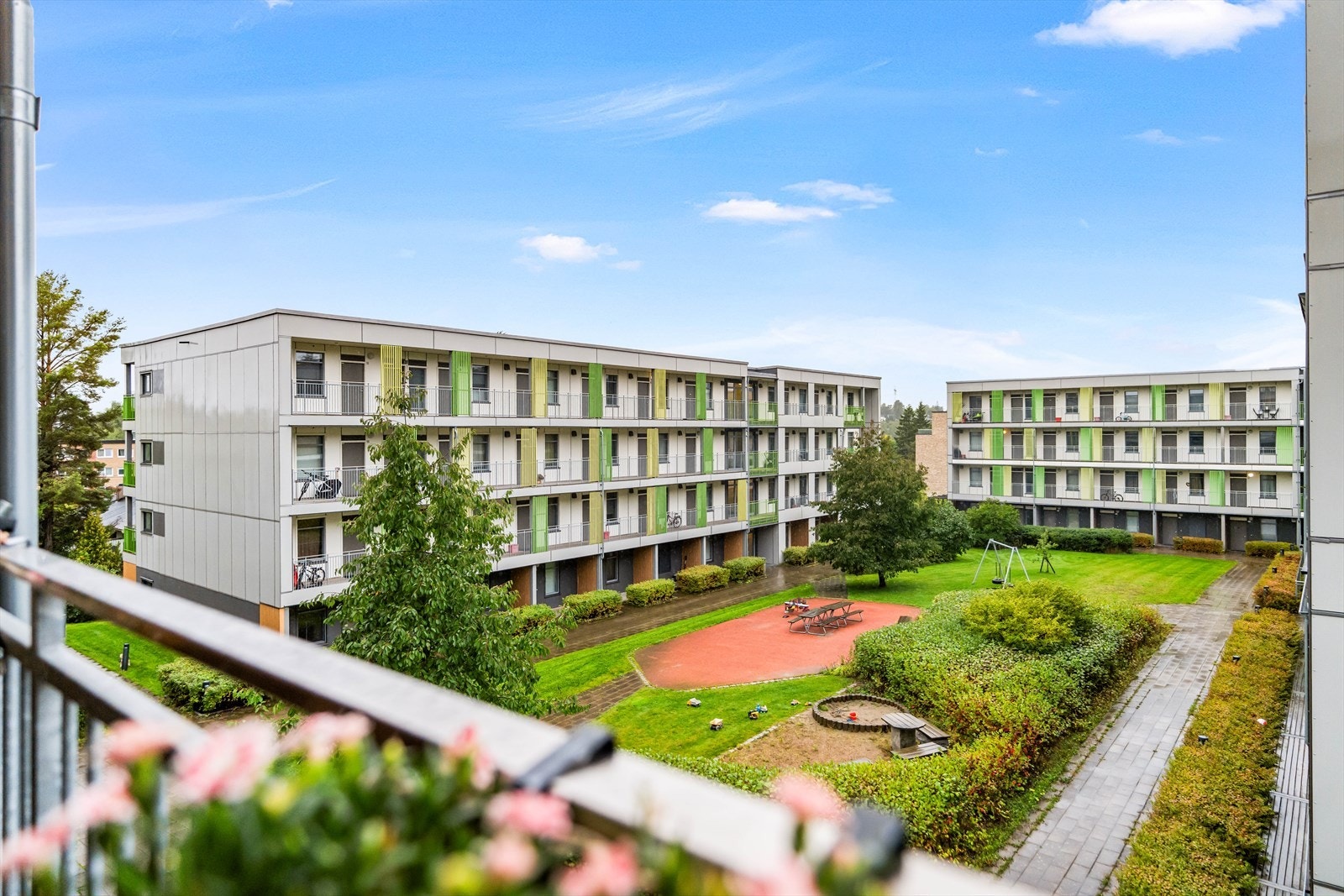 Fra balkongen har man utsikt inn mot åpent friareal og hyggelig lekeplass for barna. Galleribilde