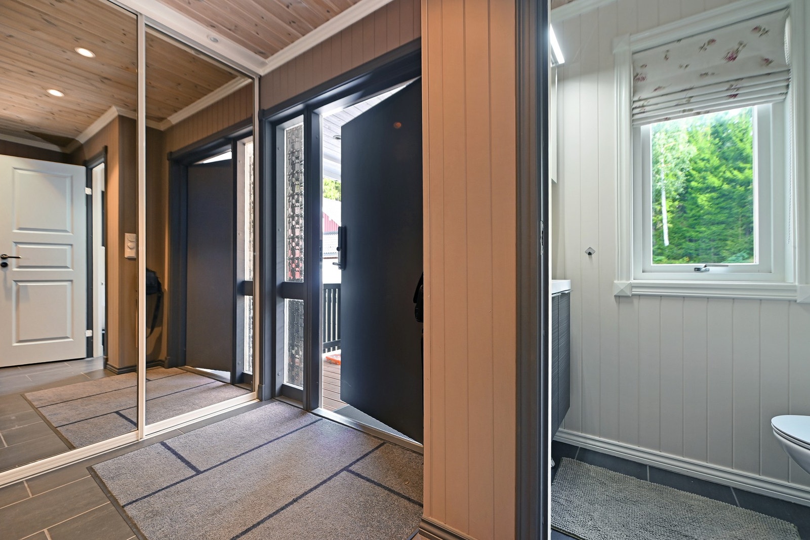 Entreen har speilskyvedørsgarderobe, flislagt gulv og adkomst til bad med vindu. Galleribilde