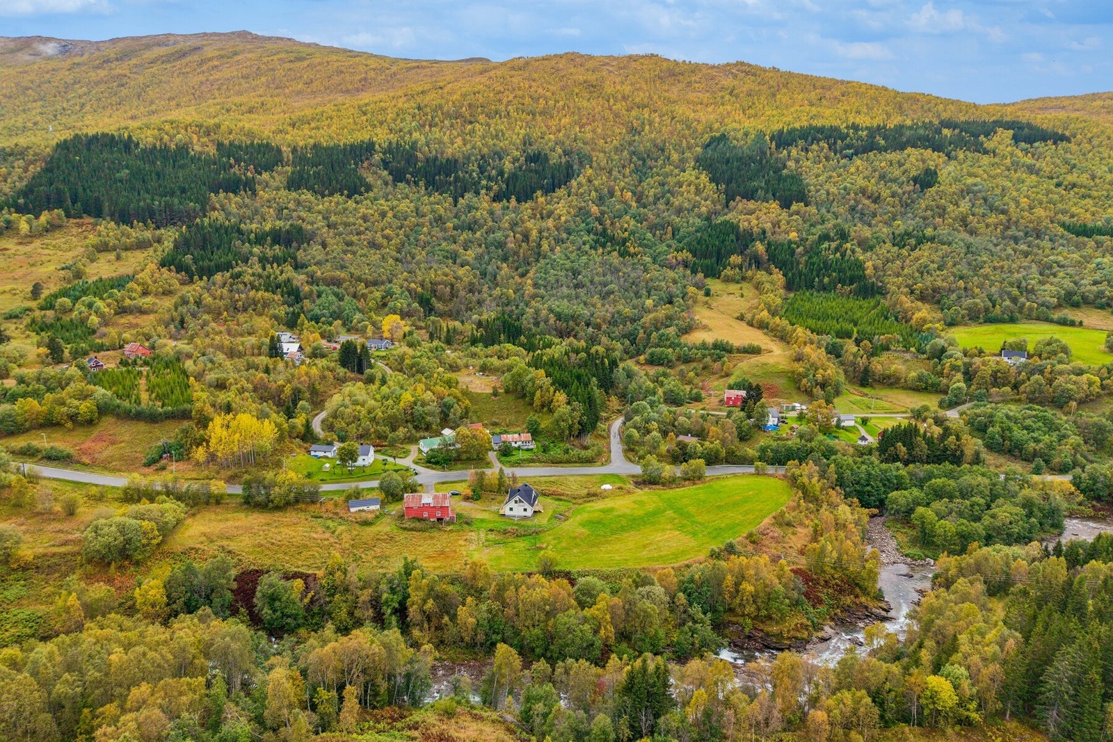 Eiendommen er omkranset av frodig skog og åpent landskap i et rolig dalføre. Galleribilde