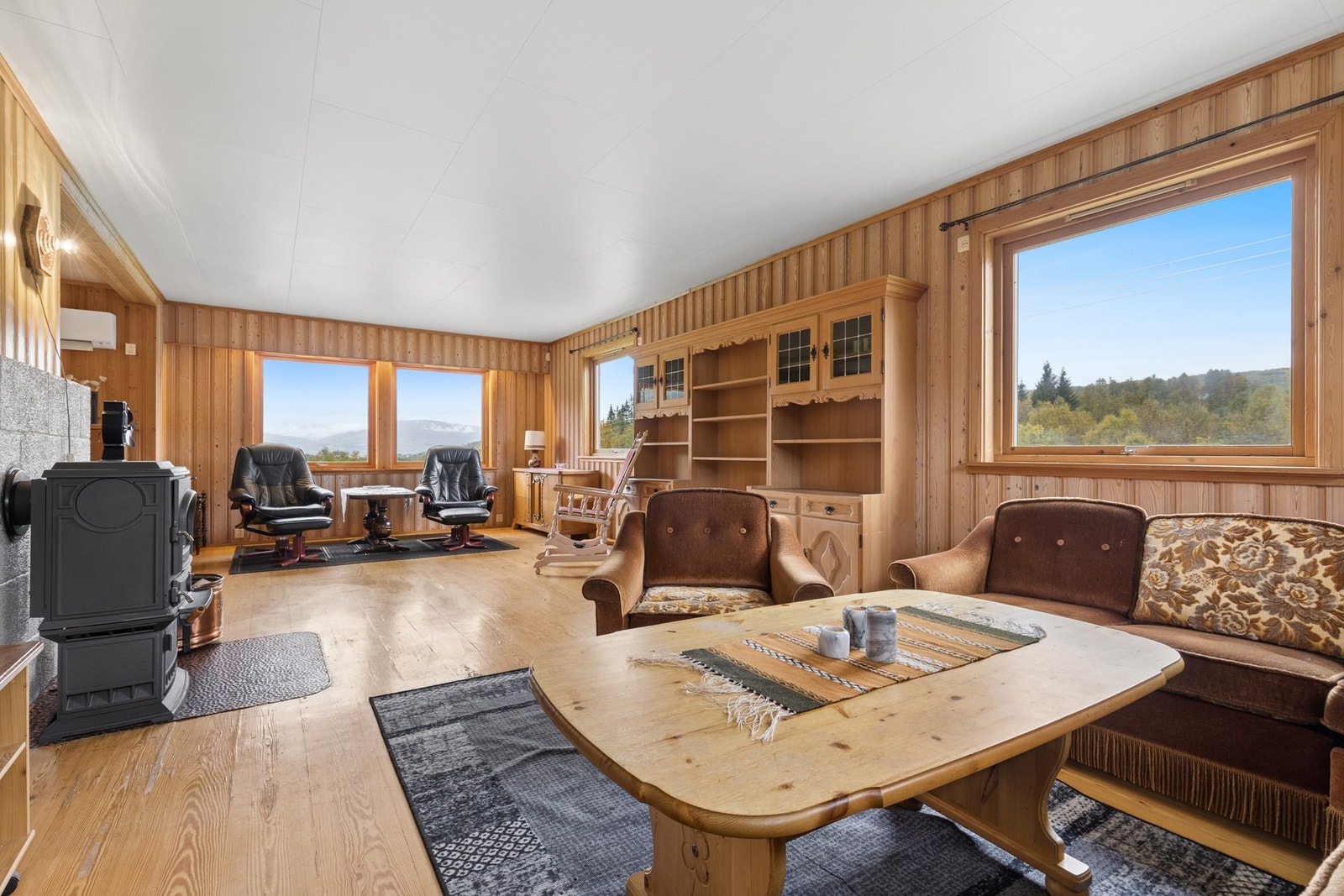 Stuen har parkett på gulvet og gode lysforhold fra flere vinduer. Galleribilde
