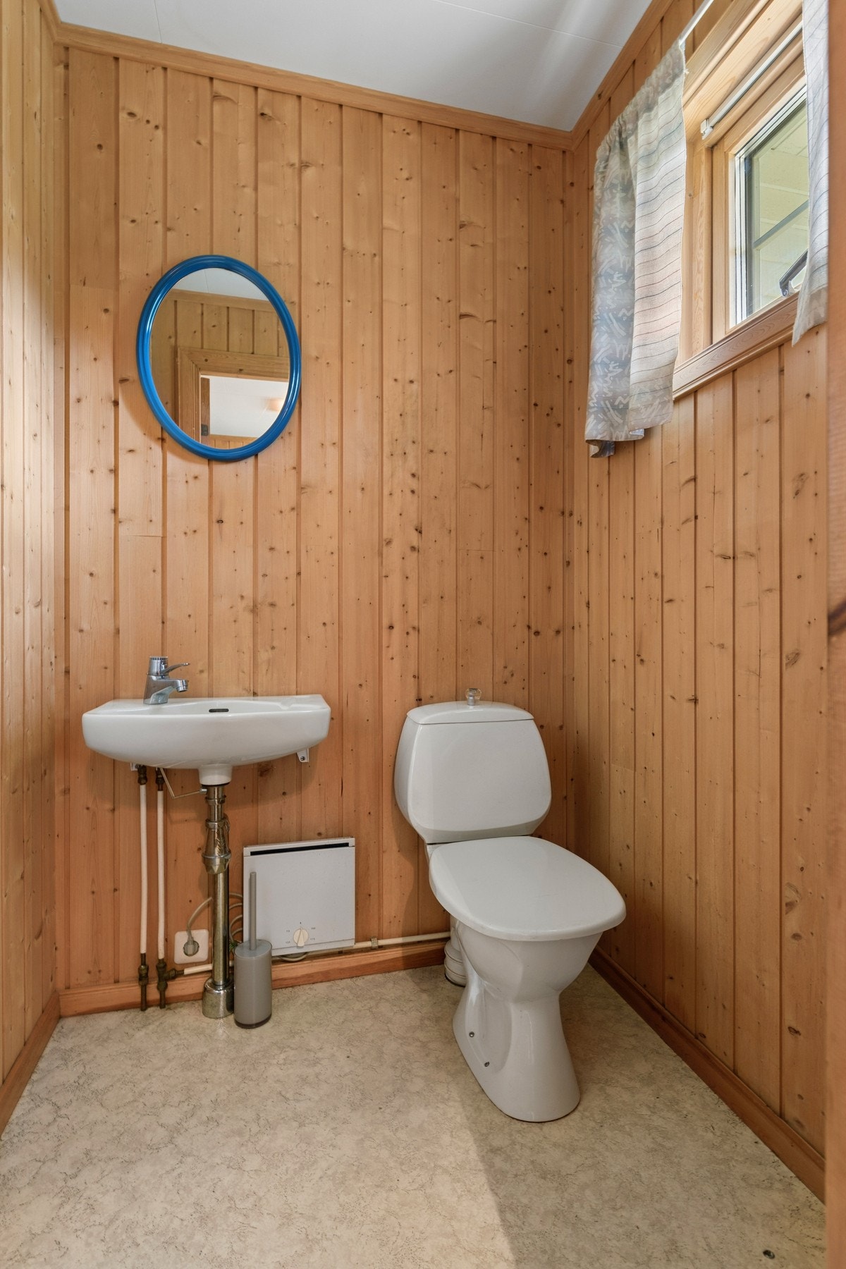 Toalettrom i 1. etasje med panel på vegger, toalett og servant. Galleribilde