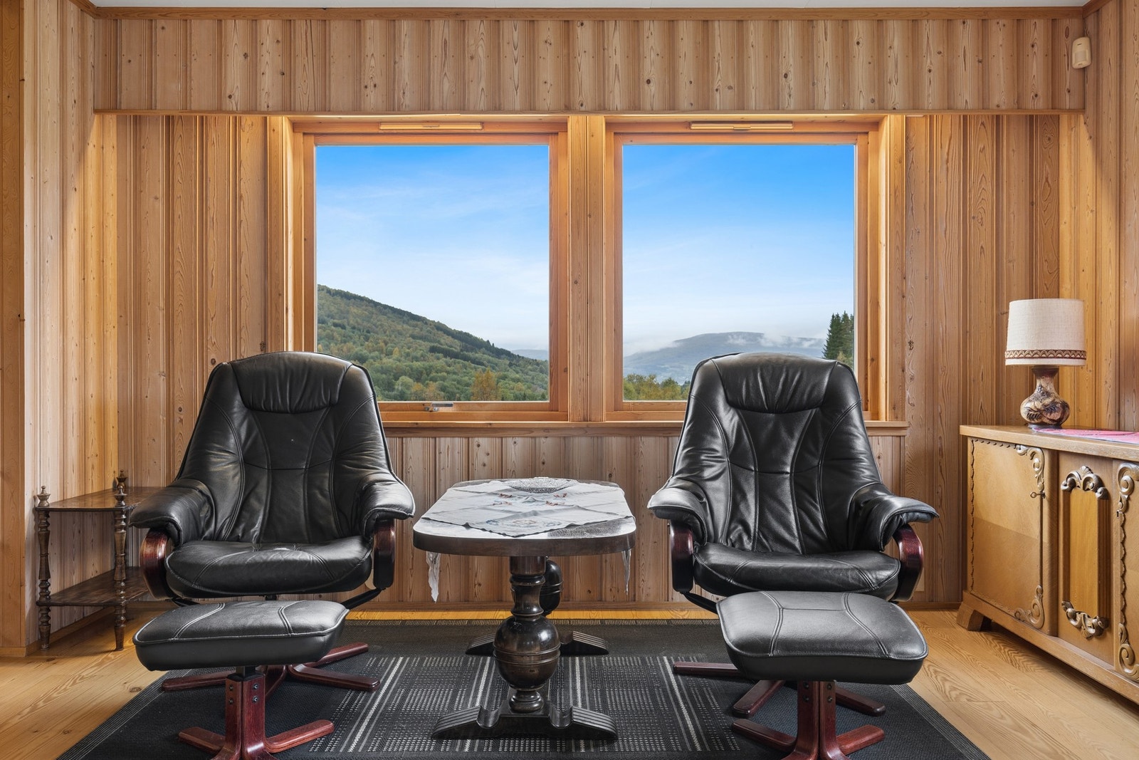 Store vindusflater rammer inn utsikten mot dalen og fjellene. Galleribilde