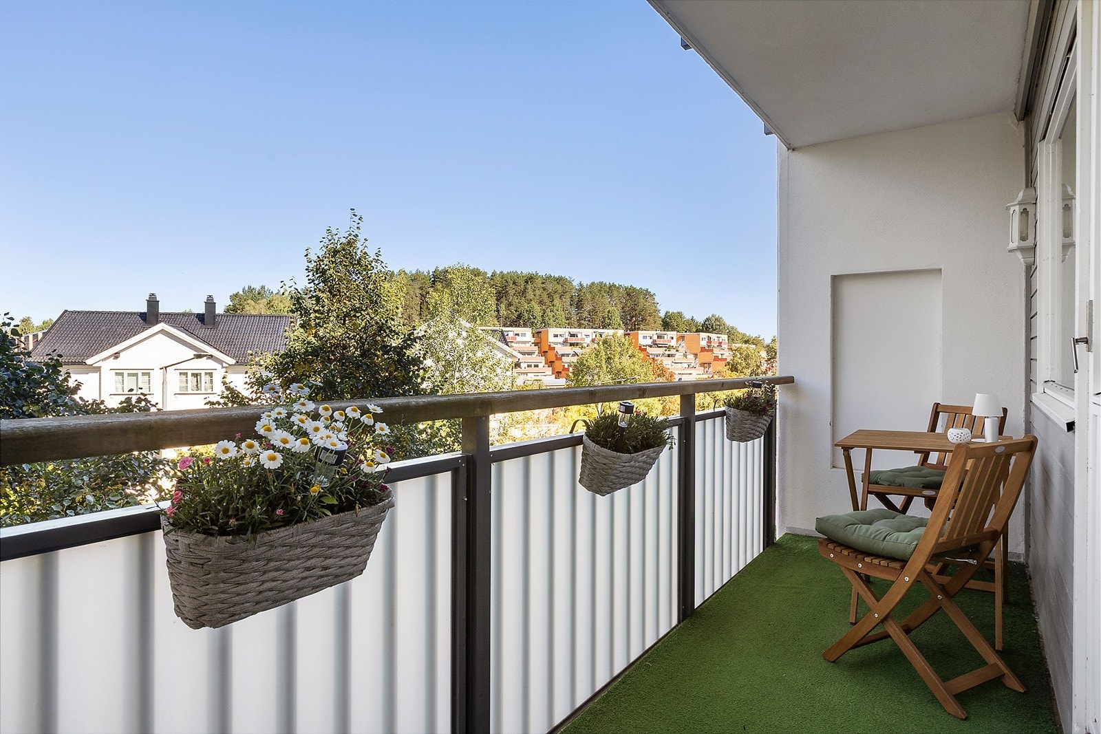 Nordvestvendt balkong med gressteppe på gulv på ca. 8,8 m². Balkongen er utstyrt med utelys. Galleribilde