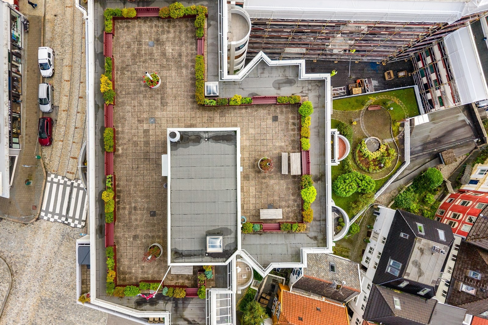 Nedenfor bygget finner vi et hyggelig, opparbeidet fellesareal med plen, beplantning, sittebenk og sirkulære hagepartier. Galleribilde