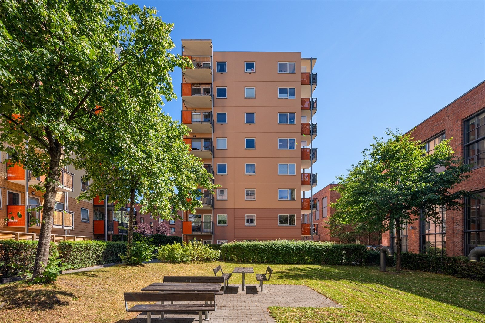 Tomten er pent opparbeidet med asfalterte internveier, grøntområder, beplantning, lekeapparater og sittegrupper. Galleribilde