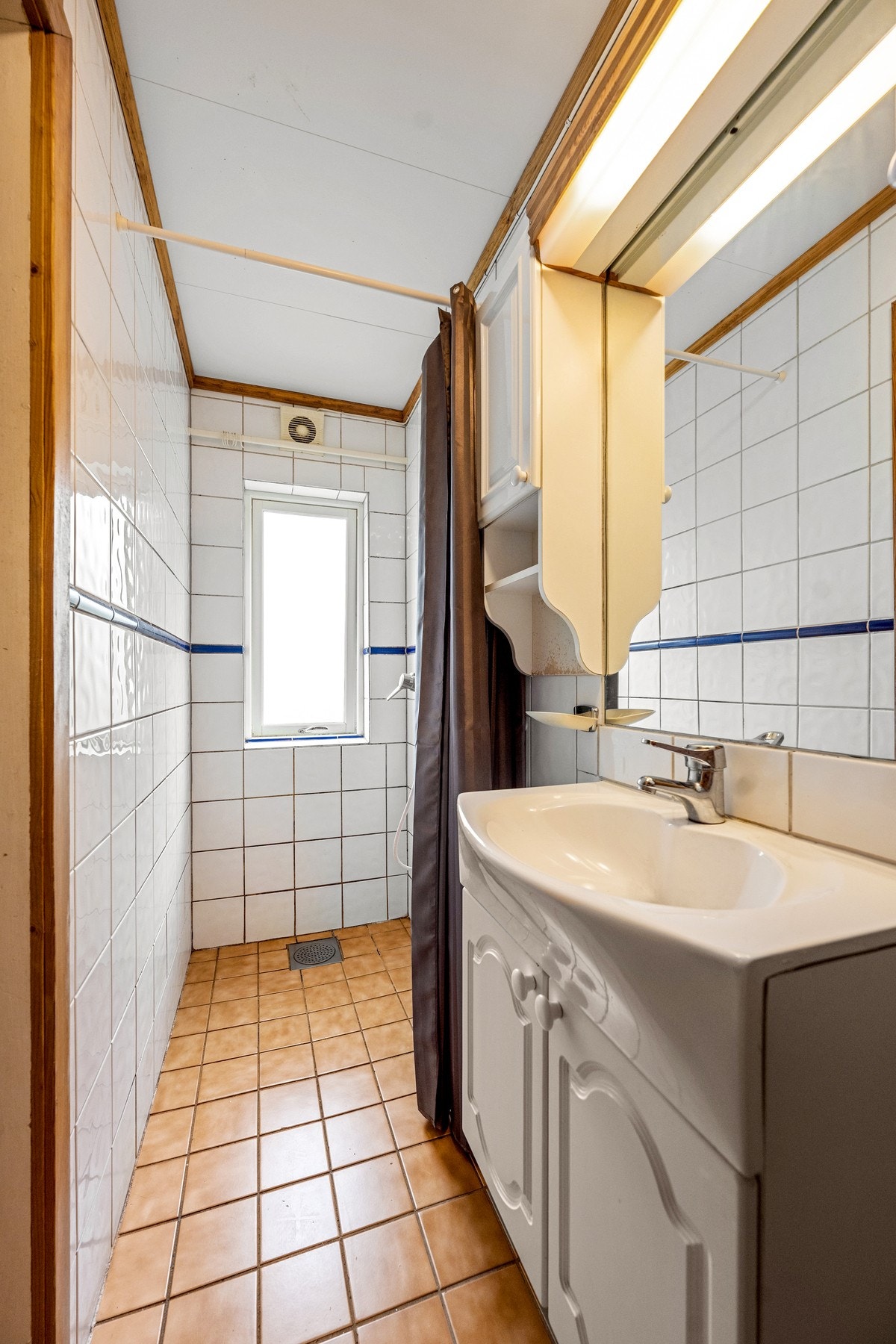 Flislagt bad med servantinnredning, speil og dusjløsning.Rommet er innredet og benyttes som bad. Badet fremgår ikke som bad av fremlagte godkjente byggetegninger. Galleribilde