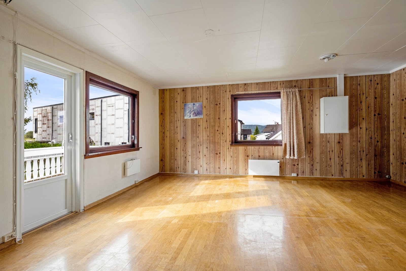 Lys og romslig stue med flere vinduer og utgang til balkong. Galleribilde