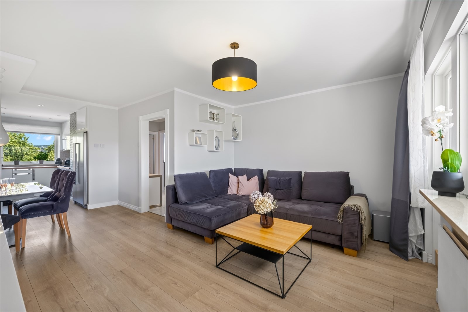 Her er det god plass til både en komfortabel sofagruppe og spisebord, samtidig som den delvis åpne løsningen mot kjøkkenet skaper en sosial og luftig atmosfære. Galleribilde