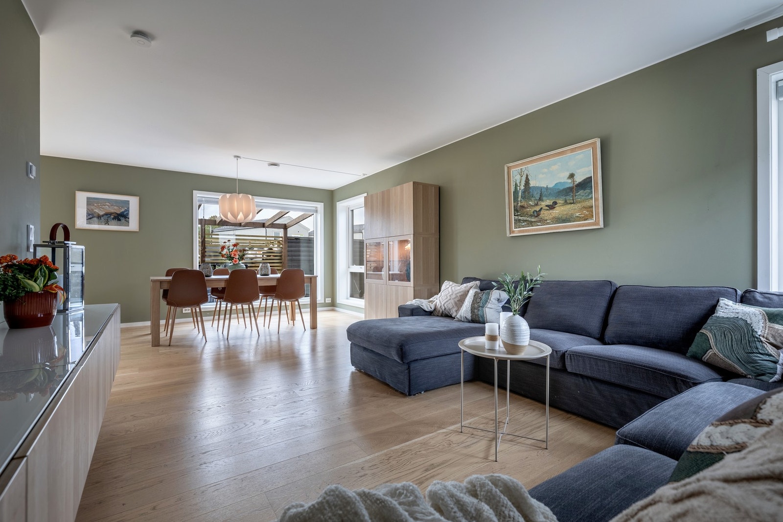 Det er god plass til sofagruppe, TV-anlegg og spisebord i naturlige soner. Veggmontert skjenk under tv medfølger. Galleribilde