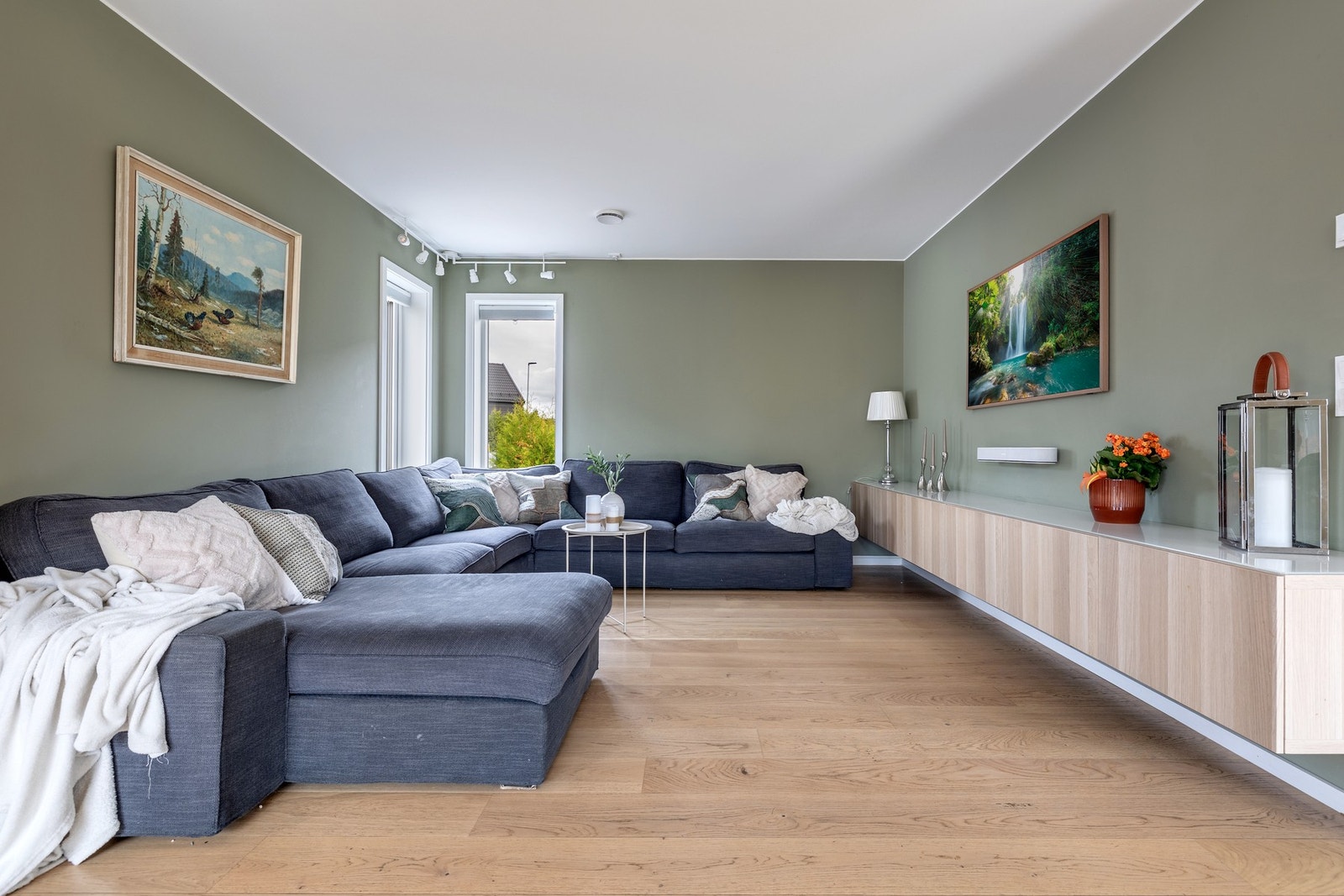 Det er god plass til sofagruppe, TV-anlegg og spisebord i naturlige soner. Veggmontert skjenk under tv medfølger. Galleribilde