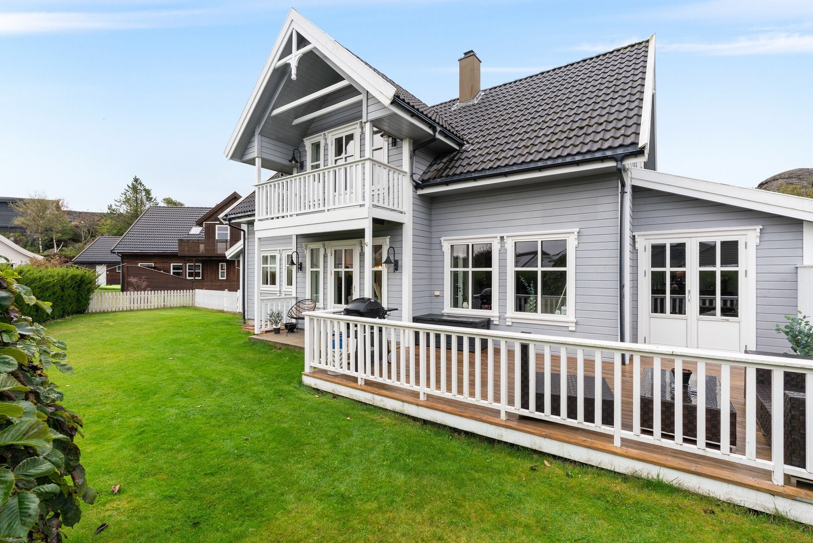 Boligen sett fra hagesiden med veranda og balkong Galleribilde
