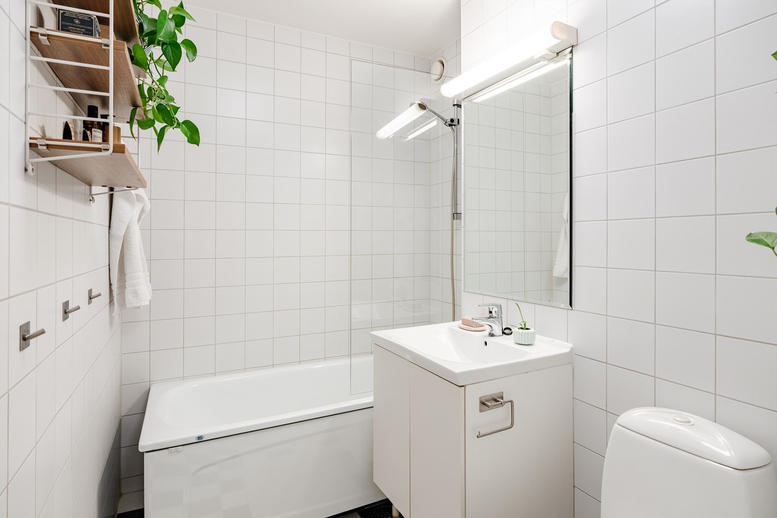 Romslig bad fra byggeår med badekar, servant med underskap og toalett. Galleribilde