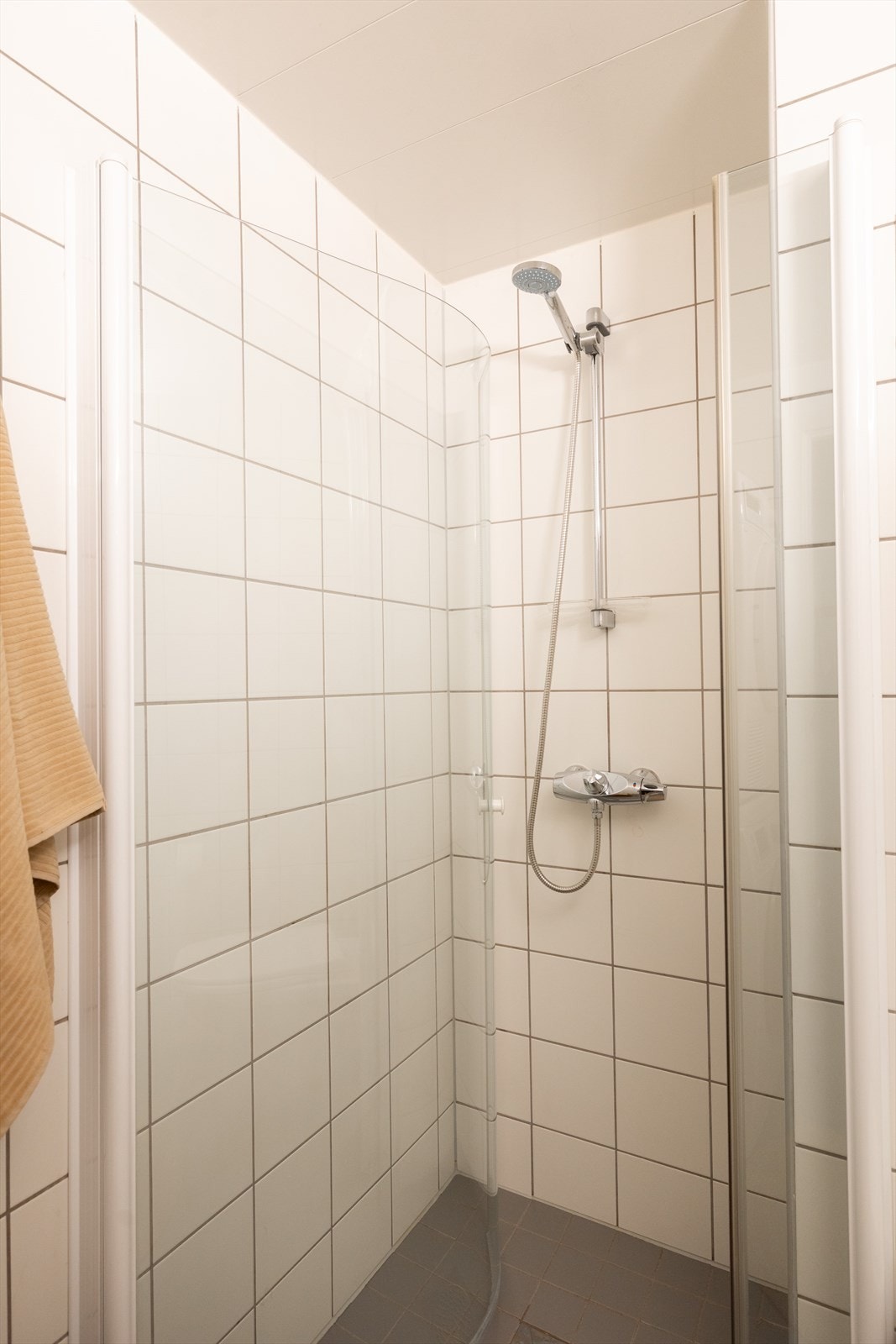 Badet er innredet med vegghengt klosett, servant nedfelt i innredning, speilskap og dusjhjørne med svingbare glassdører. Galleribilde