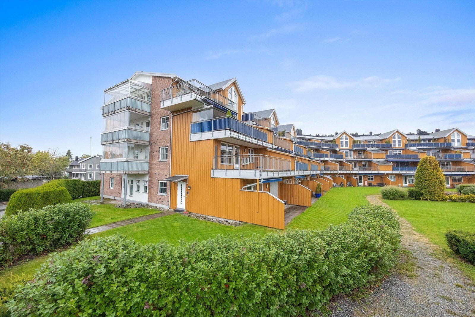 Terrassert leilighetsbygg med felles parkanlegg og grønne plenarealer. Galleribilde