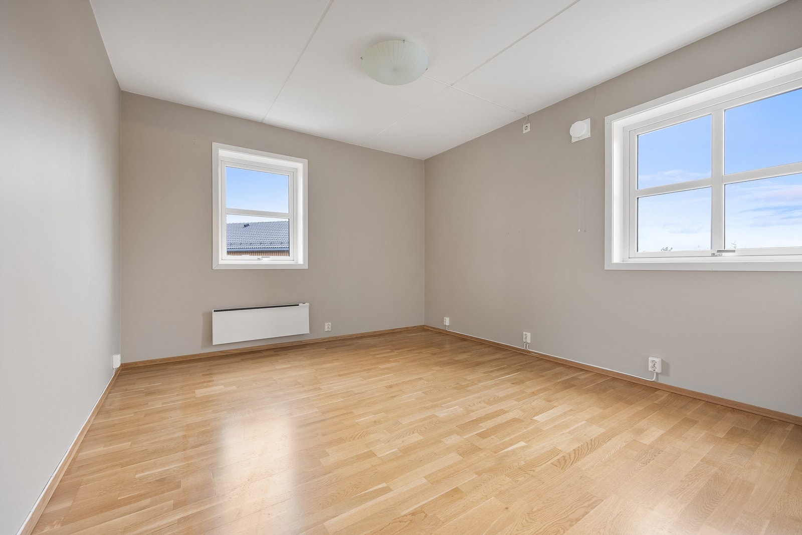 Hovedsoverom med vinduer på to vegger og god plass til dobbeltseng. Galleribilde
