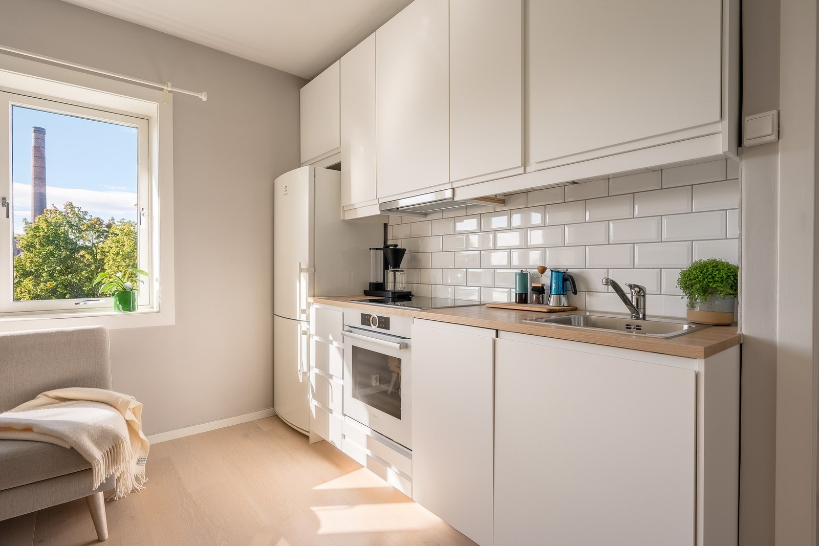 Kjøkkeninnredning fra 2017 med hvite, matte fronter, benkeplate i laminert overflate og nedfelt kjøkkenvask med armatur Galleribilde