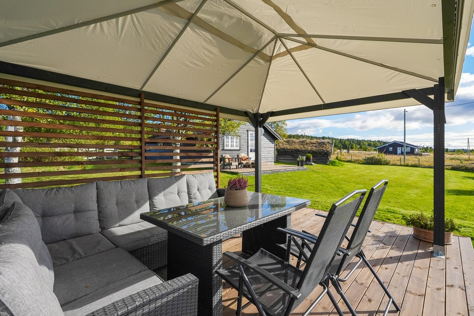 Her kan lange sommerdager nytes i ly for både sol og lett regn, enten man samles rundt spisebordet til middag, nyter morgenkaffen eller slapper av med utsikten over det åpne stølslandskapet. Galleribilde